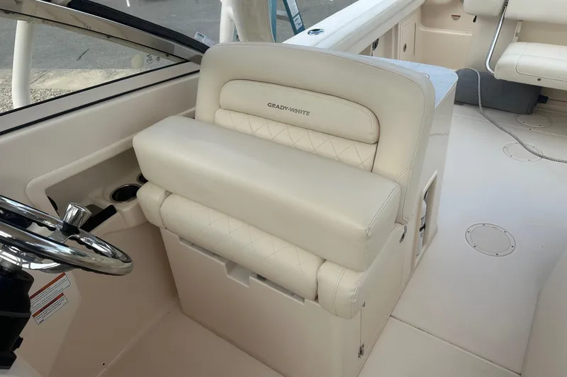 Slide: The Image of 2022 Grady-White Freedom 275 boat interior with plush seating and steering wheel. - 8