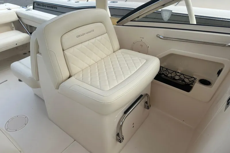 Slide: The Image of 2022 Grady-White Freedom 275 boat interior with luxurious white seating and storage. - 9