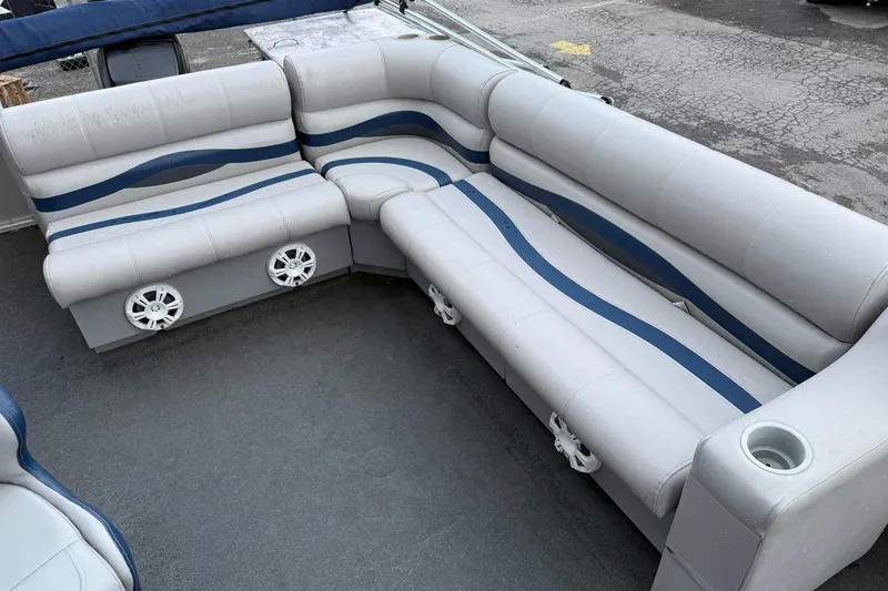 Slide: The Image of 1999 Sun Tracker PARTY BARGE 25 interior with white and blue seating, cup holders, and speakers. - 4