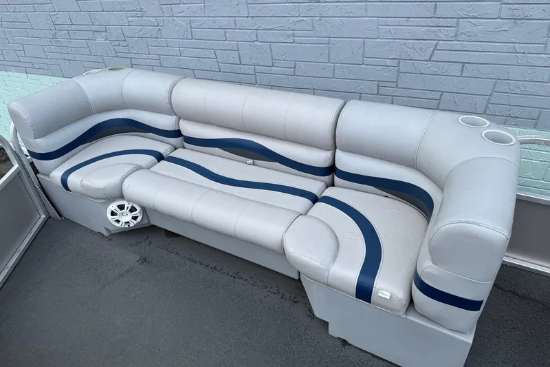 Slide: The Image of 1999 Sun Tracker PARTY BARGE 25 boat seating with blue and white upholstery, cup holders, and speaker. - 5