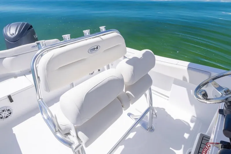 Slide: The Image of 2026 Sea Hunt Ultra 234 boat interior with white seating and ocean view. - 10