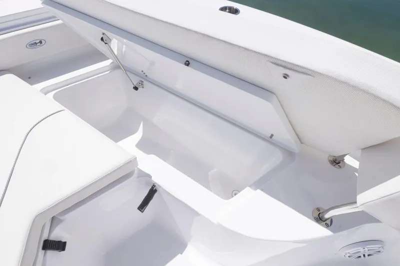 Slide: The Image of 2026 Sea Hunt Ultra 234 boat storage compartment with open cushioned seat. - 3