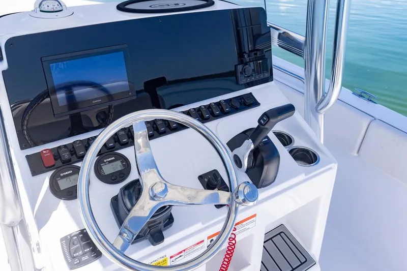 Slide: The Image of 2026 Sea Hunt Ultra 234 boat dashboard with steering wheel and navigation controls. - 8
