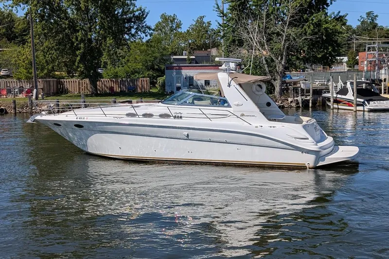 The Image of 1998 Sea Ray 370 Sundancer yacht on calm water near a dock. - 0