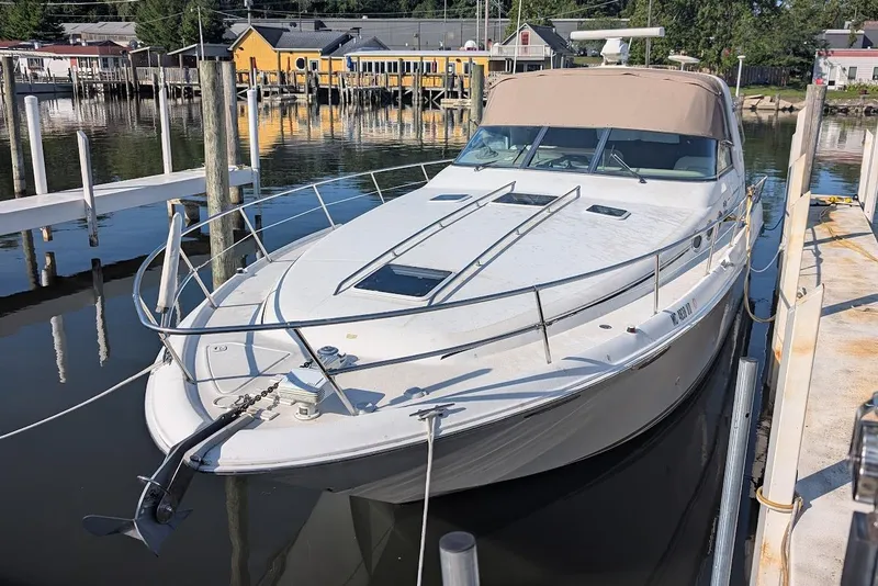 Slide: The Image of 1998 Sea Ray 370 Sundancer docked at a marina, featuring sleek design and spacious deck. - 10