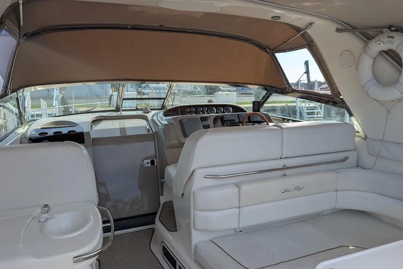 Slide: The Image of 1998 Sea Ray 370 Sundancer interior with white seating and helm, showcasing luxury design. - 15