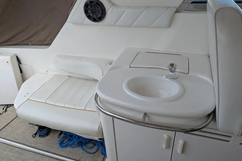 Slide: The Image of Interior of 1998 Sea Ray 370 Sundancer with white seating and compact sink area. - 18