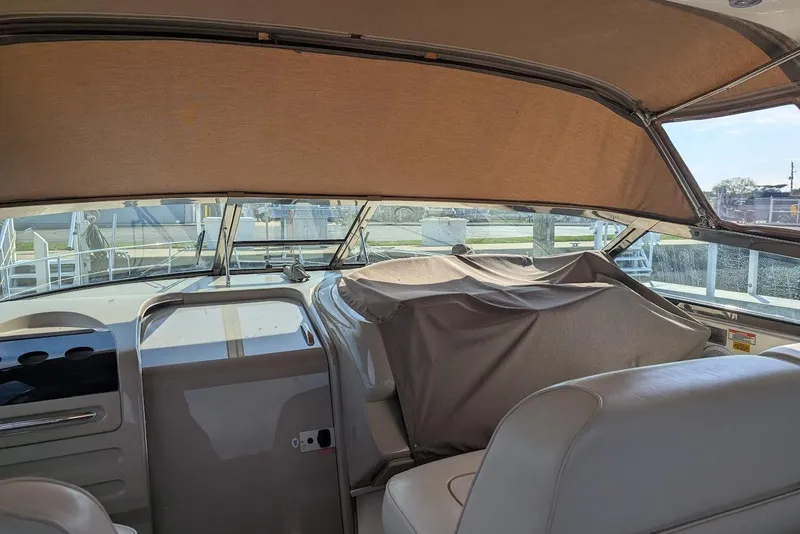 Slide: The Image of 1998 Sea Ray 370 Sundancer cockpit with covered dashboard and beige interior. - 21