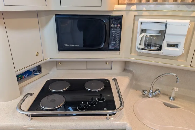 Slide: The Image of 1998 Sea Ray 370 Sundancer kitchen with stove, microwave, coffee maker, and sink. - 30