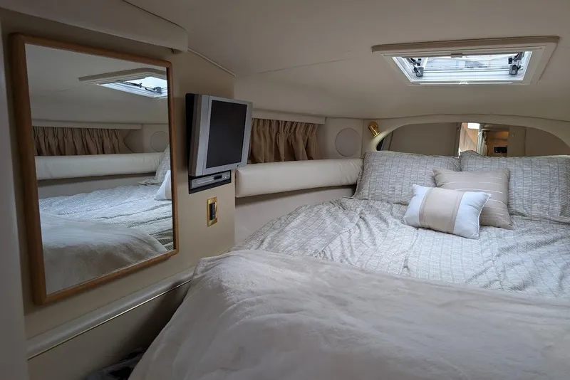Slide: The Image of Interior cabin of 1998 Sea Ray 370 Sundancer with bed, mirror, and TV. - 40