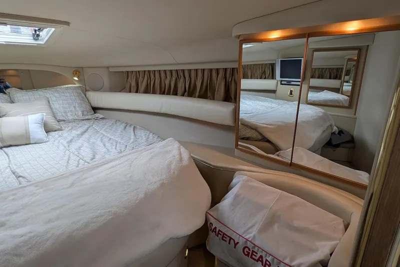 Slide: The Image of Luxurious cabin interior of 1998 Sea Ray 370 Sundancer with cozy bedding and mirrored accents. - 43