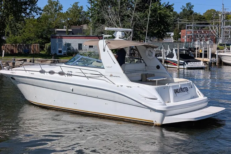 Slide: The Image of 1998 Sea Ray 370 Sundancer yacht docked in a marina, surrounded by trees and buildings. - 5