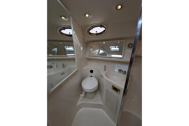 Slide: The Image of 1998 Sea Ray 370 Sundancer bathroom with toilet, sink, and mirror. - 51