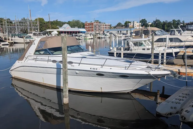 Slide: The Image of 1998 Sea Ray 370 Sundancer docked at a marina, surrounded by other boats. - 7