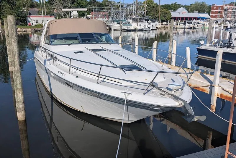 Slide: The Image of 1998 Sea Ray 370 Sundancer docked at marina, featuring sleek design and spacious deck. - 9