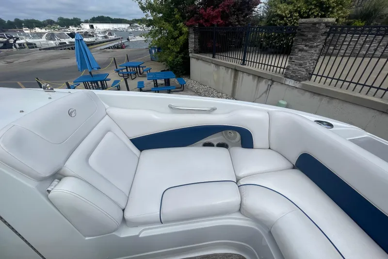Slide: The Image of 2012 Crownline Eclipse 2 boat interior with white and blue seating, dockside view. - 23