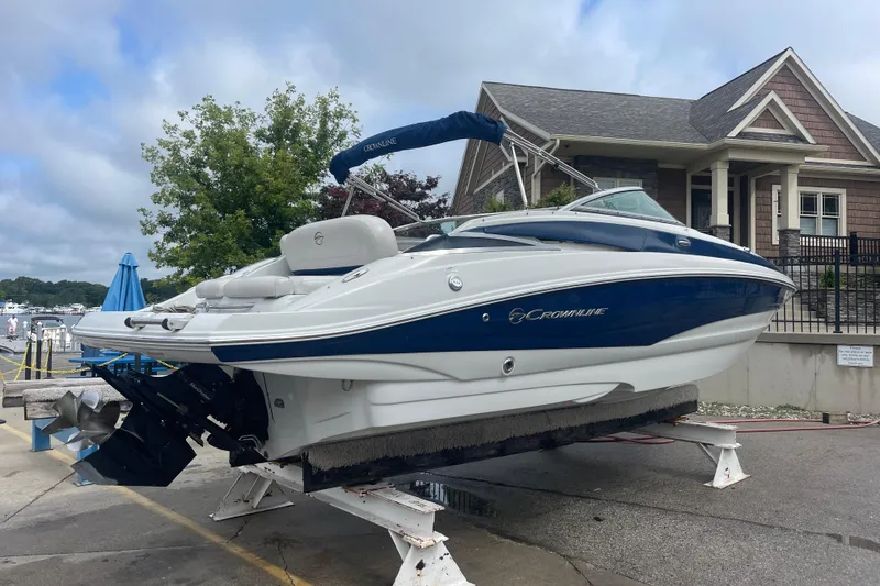 Slide: The Image of 2012 Crownline Eclipse 2 boat on a stand near a marina, with a house in the background. - 3
