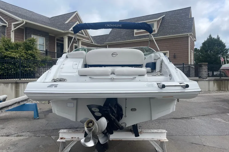 Slide: The Image of 2012 Crownline Eclipse 2 boat with canopy, parked near a house. - 4