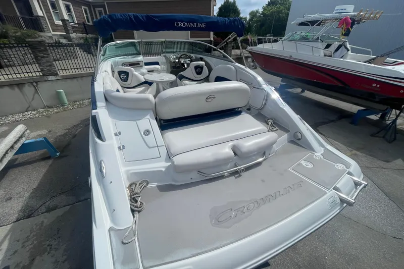 Slide: The Image of 2012 Crownline Eclipse 2 boat with spacious seating and sleek design in a marina setting. - 5