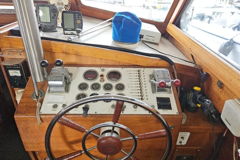 Slide: The Image of 1968 Egg Harbor Sedan boat dashboard with steering wheel and navigation instruments. - 13