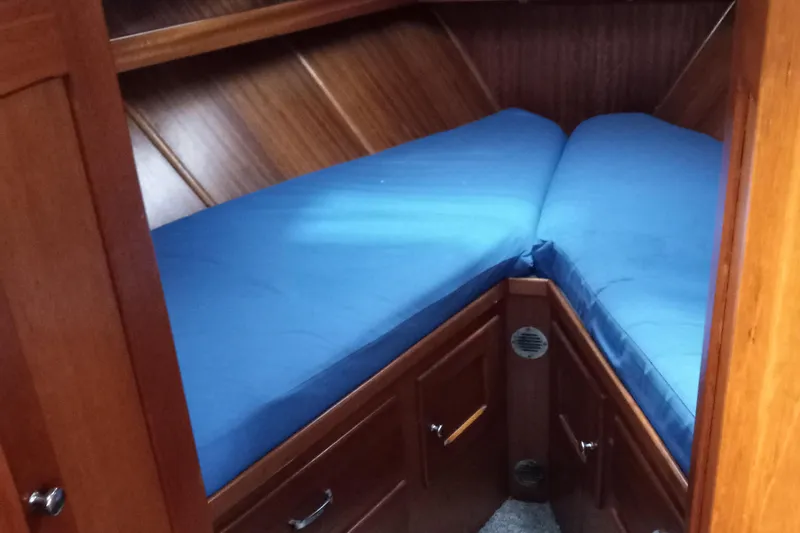 Slide: The Image of 1968 Egg Harbor Sedan interior with blue V-berth and wooden cabinetry. - 15