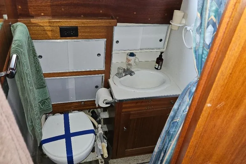 Slide: The Image of 1968 Egg Harbor Sedan bathroom with sink, toilet, and wooden cabinetry. - 18