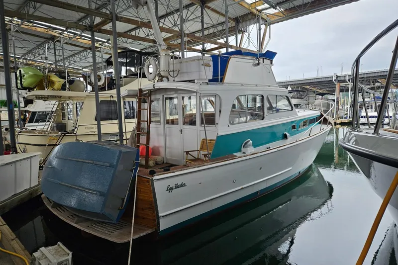 Slide: The Image of 1968 Egg Harbor Sedan boat docked in a marina under a covered structure. - 19