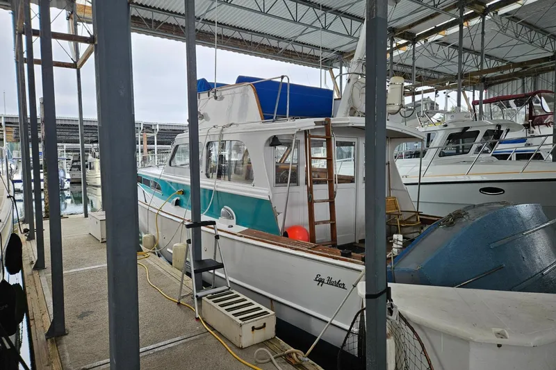 Slide: The Image of 1968 Egg Harbor Sedan boat docked in a marina under a covered structure. - 20