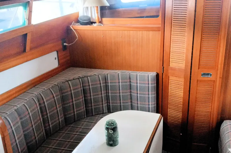 Slide: The Image of 1968 Egg Harbor Sedan interior with plaid seating, wooden paneling, and a small table. - 9