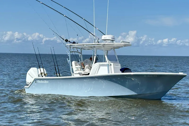 Slide: The Image of 2022 Onslow Bay 27 boat on open water, equipped with fishing rods and outboard motors. - 1