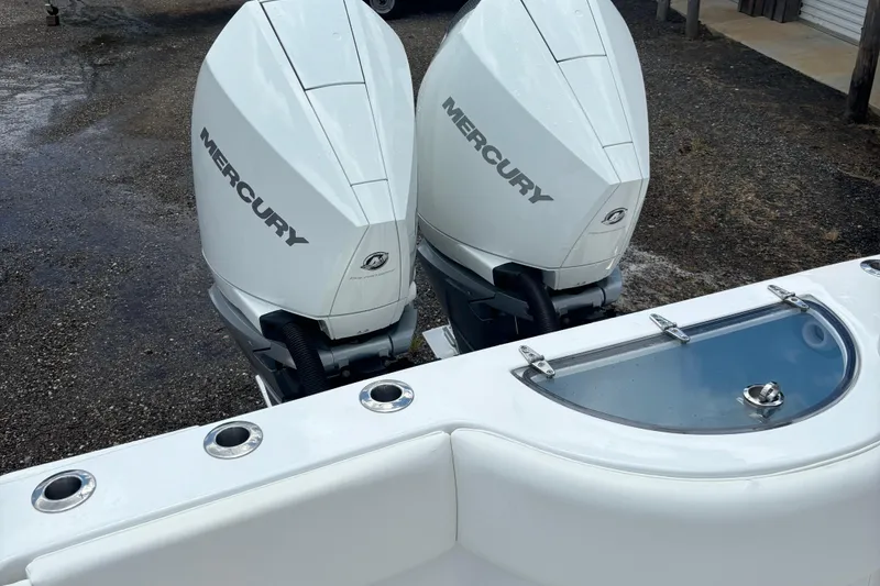 Slide: The Image of Twin Mercury outboard engines on a 2022 Onslow Bay 27 boat, featuring a livewell. - 5