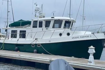 The Image of 2006 American Tug 41 boat in harbor, green hull, clear sky, calm water. - 0