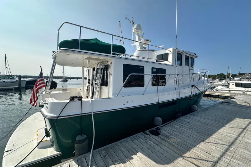 Slide: The Image of 2006 American Tug 41 boat anchored in marina, clear sky, calm water. - 1