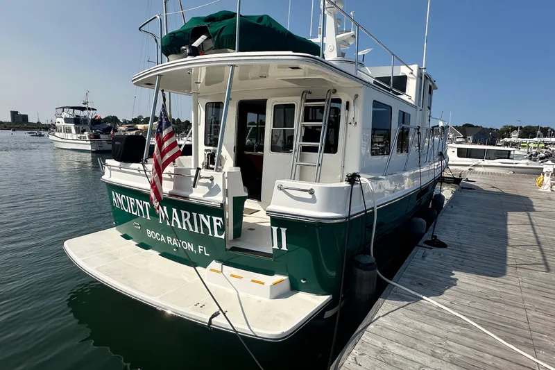Slide: The Image of 2006 American Tug 41 boat named "Ancient Mariners II" on water with American flag. - 2