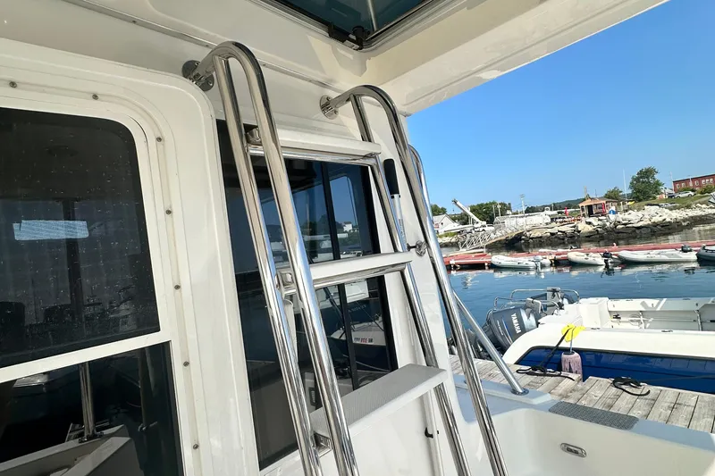 Slide: The Image of 2006 American Tug 41 docked, showcasing spacious deck and marina view. - 34