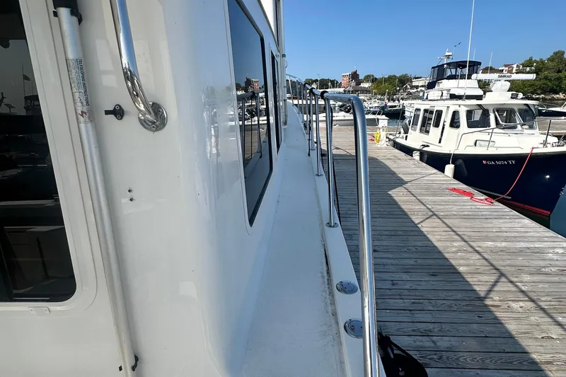 Slide: The Image of Interior view of a 2006 American Tug 41 boat with cushioned seating. - 36