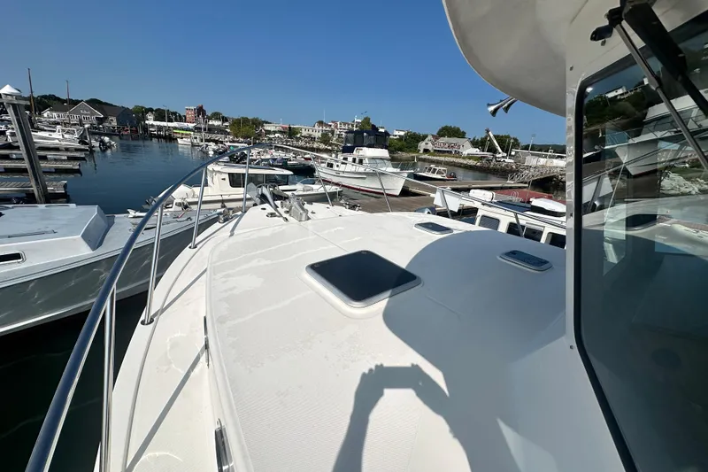 Slide: The Image of 2006 American Tug 41 docked at a marina, showcasing its spacious deck and sleek design. - 39