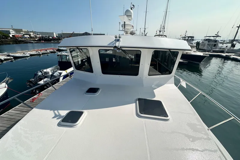 Slide: The Image of 2006 American Tug 41 docked at a marina, showcasing its spacious deck and sleek design. - 40