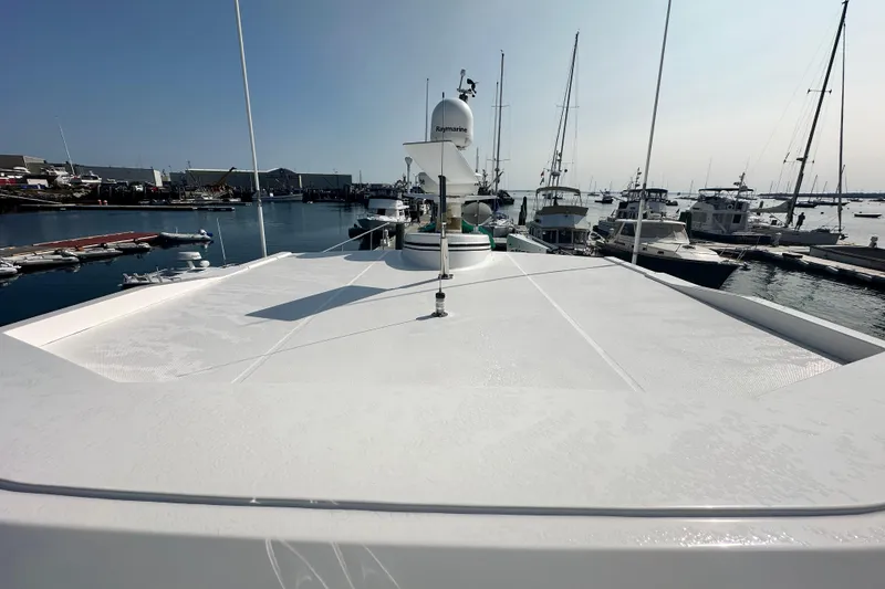 Slide: The Image of 2006 American Tug 41 docked at marina, showcasing spacious deck and cabin windows. - 41