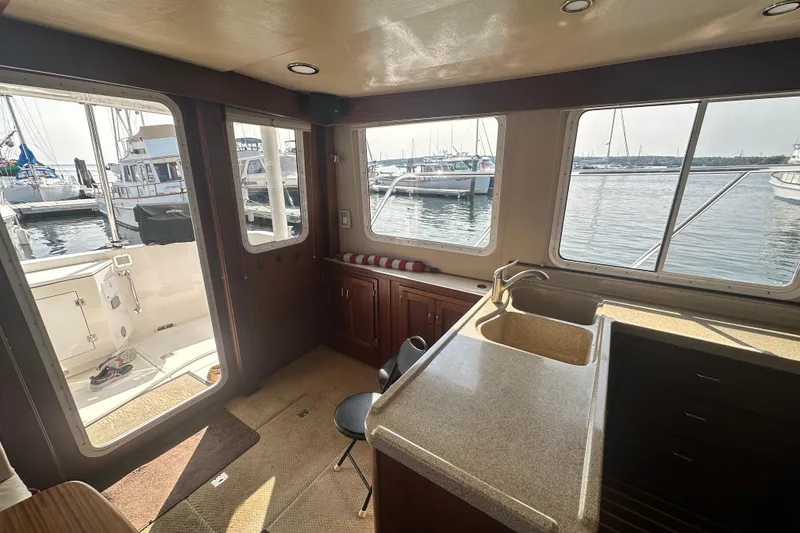 Slide: The Image of Interior of 2006 American Tug 41 with wood cabinetry and waterfront view. - 9