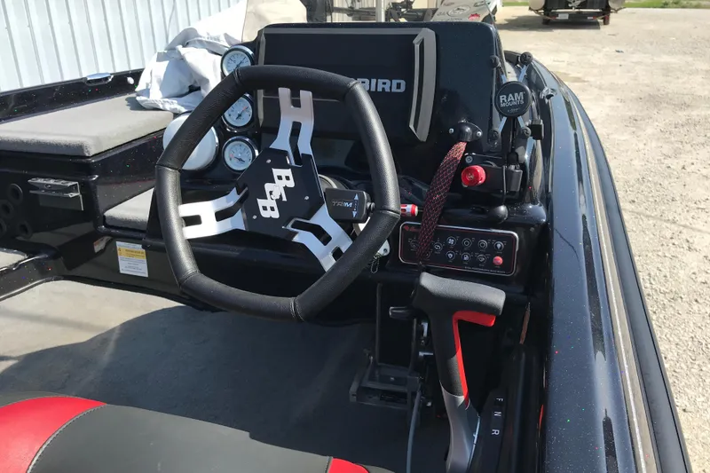 Slide: The Image of 2023 Bass Cat Pantera II boat dashboard with steering wheel and control panel. - 12