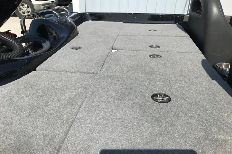 Slide: The Image of 2023 Bass Cat Pantera II boat deck with gray carpet and storage compartments. - 16