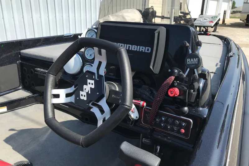 Slide: The Image of 2023 Bass Cat Pantera II boat dashboard with steering wheel and electronic controls. - 17
