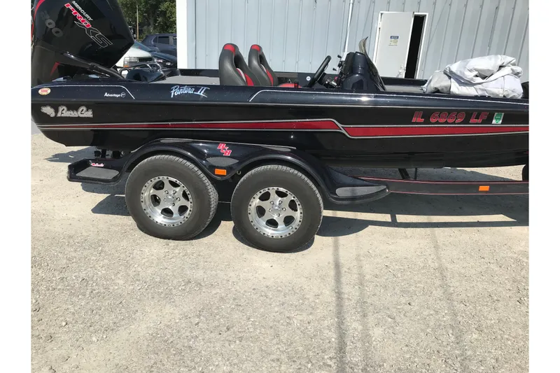 Slide: The Image of 2023 Bass Cat Pantera II boat on trailer, black with red accents, parked outdoors. - 9