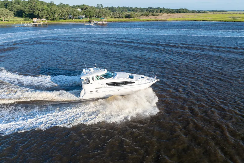 Slide: The Image of 2007 Sea Ray 40 Motor Yacht cruising on a scenic river with lush greenery. - 24