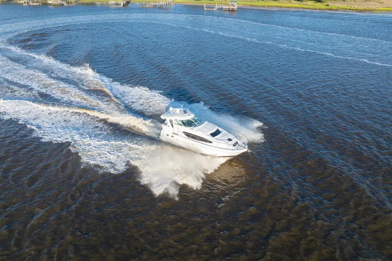 Slide: The Image of 2007 Sea Ray 40 Motor Yacht cruising on open water, creating a dynamic wake. - 25