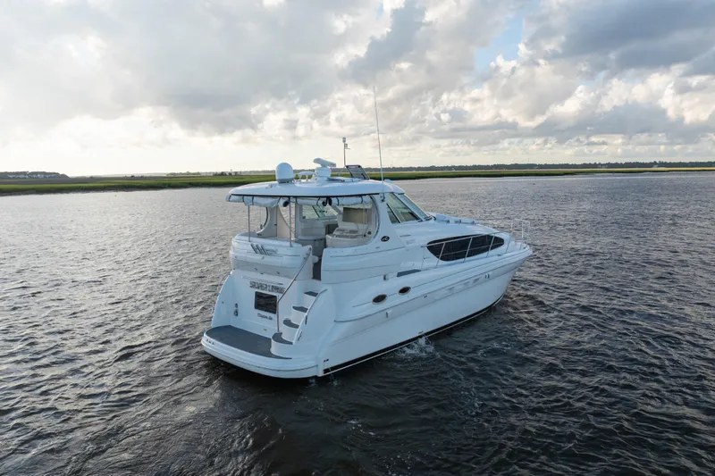 Slide: The Image of 2007 Sea Ray 40 Motor Yacht cruising on a serene waterway under a cloudy sky. - 3