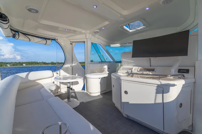 Slide: The Image of Luxurious 2007 Sea Ray 40 Motor Yacht interior with seating, table, and TV, overlooking water. - 58