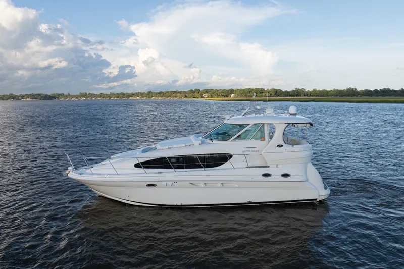 Slide: The Image of 2007 Sea Ray 40 Motor Yacht cruising on a serene lake under a partly cloudy sky. - 6