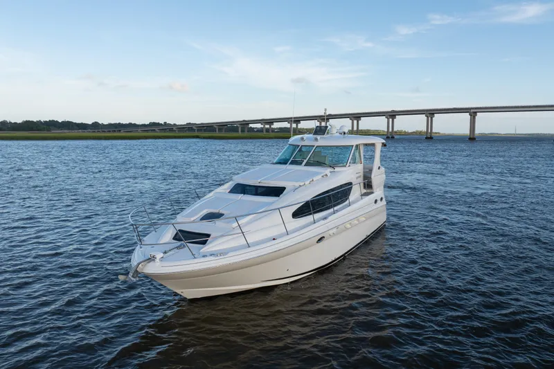 Slide: The Image of 2007 Sea Ray 40 Motor Yacht on calm water near a bridge under a clear sky. - 7